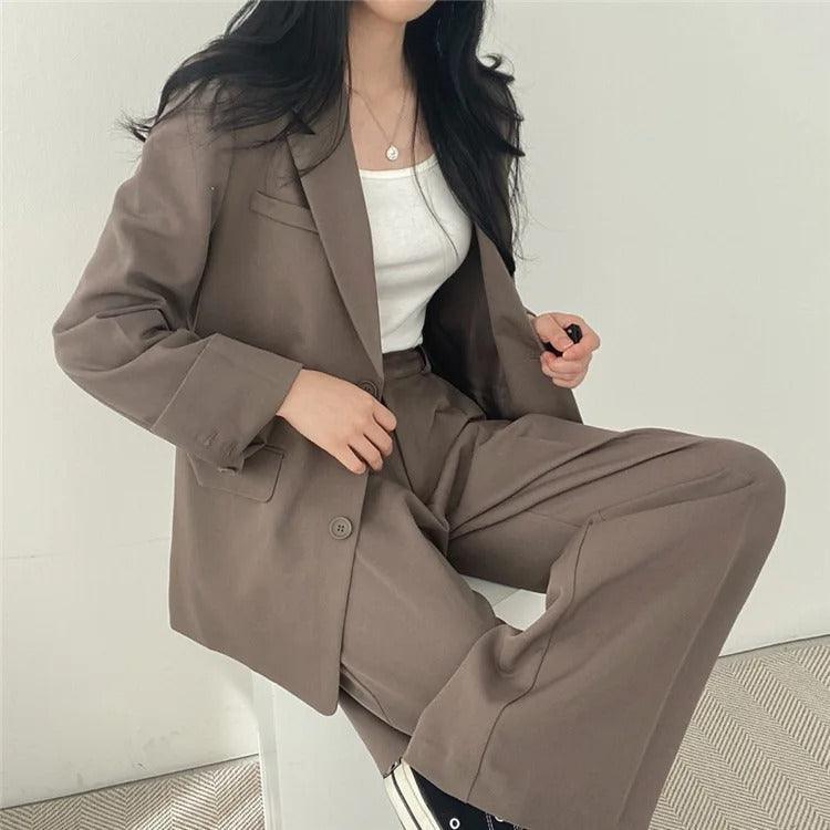 Slim-fit women's tailored suit with a long blazer and matching trousers for a streamlined silhouette.