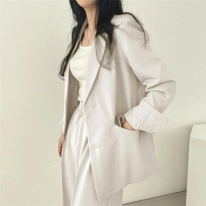 Professional women's workwear: a two-piece suit with a long blazer and sleek tailored trousers.