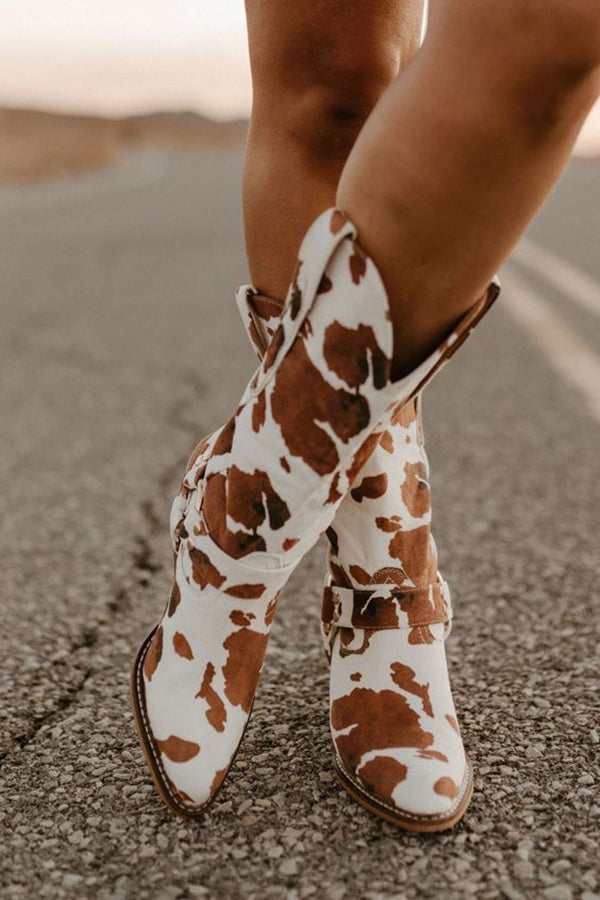 Stylish women's Western boots with unique cow print design and decorative belt detail