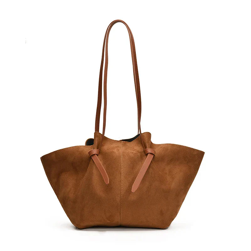 Side profile of women's faux suede tote handbag, showcasing its structured yet soft shape