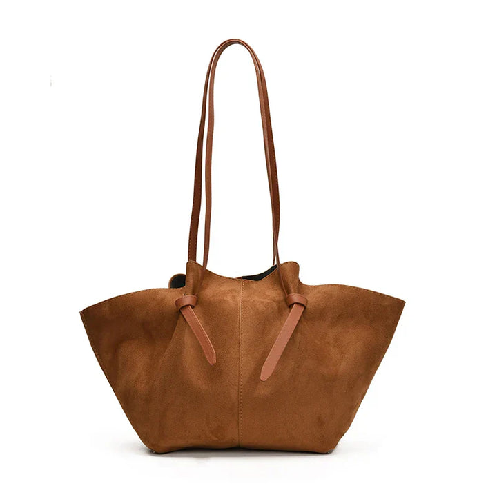 Side profile of women's faux suede tote handbag, showcasing its structured yet soft shape