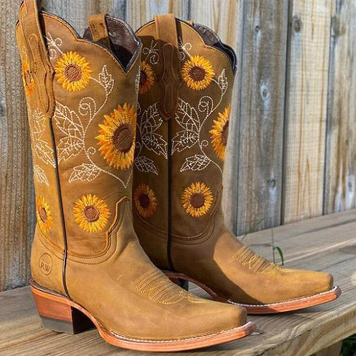 Women's Western cowboy boots with vibrant sunflower embroidery, pointed toe, and sturdy block heel. Perfect for festivals.