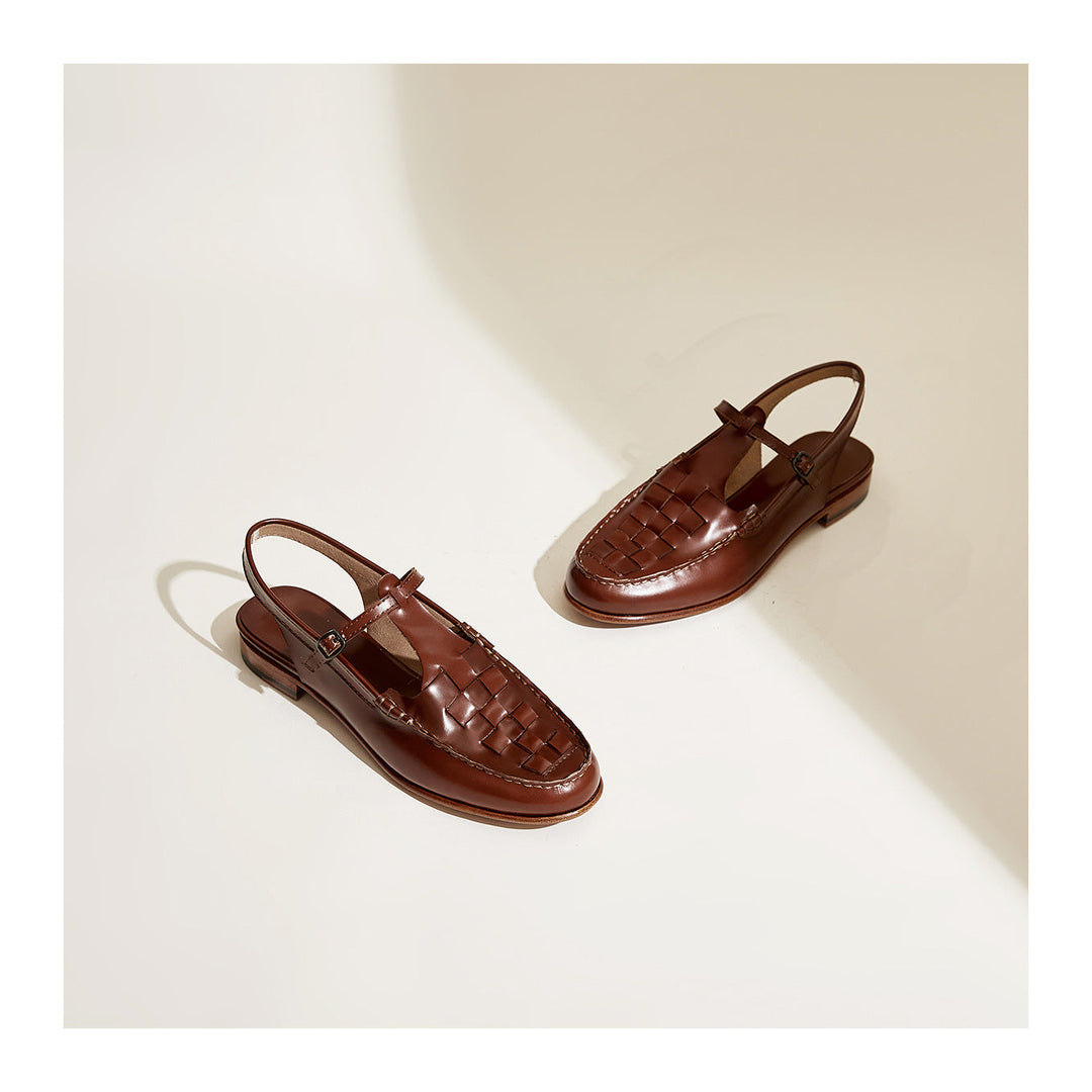 Image of ergonomic women's flat leather sandals featuring a unique woven slingback design.