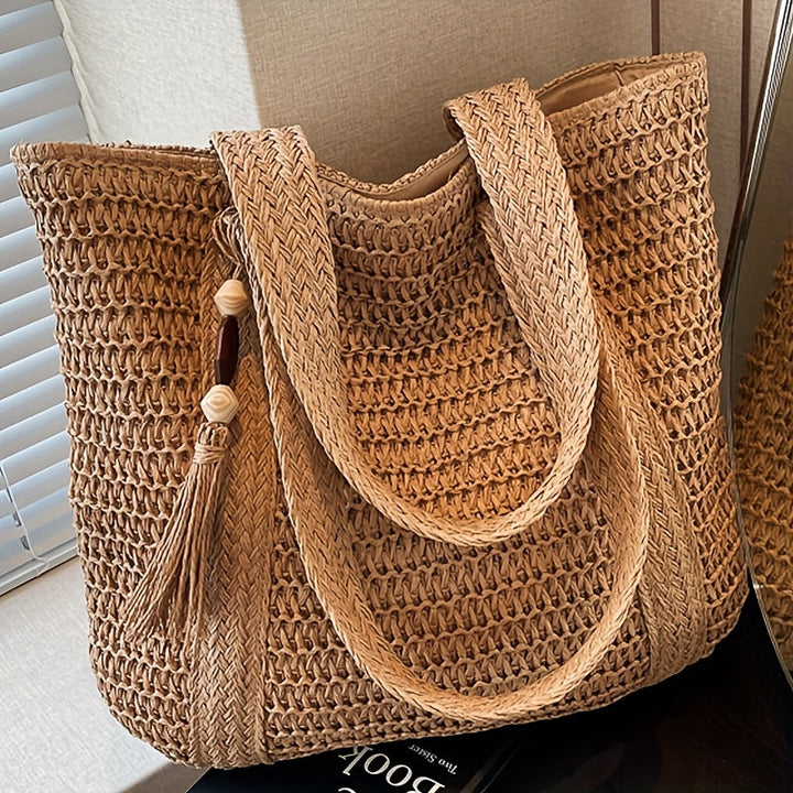 Chic women's straw tote bag with distinctive fringe and a stylish tassel, great for beach or summer.