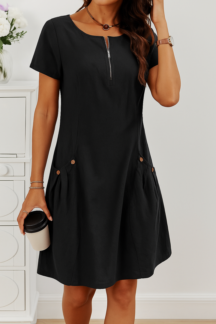 Woman wearing a comfortable zip front short sleeve midi dress with pockets. Perfect for a casual day out.