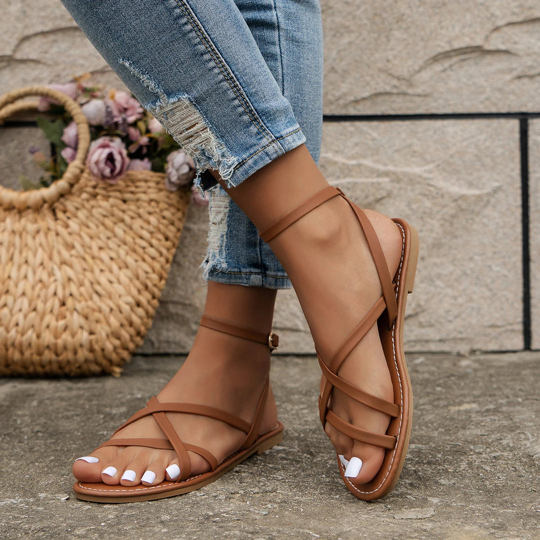 Women's criss-cross strap flat sandals with open-toe, side view, sleek design, perfect for summer outings.