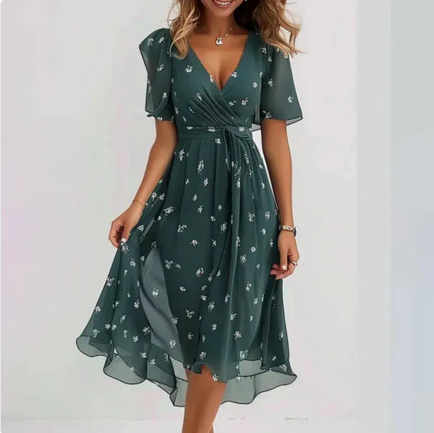 Women's floral wrap midi dress with flutter sleeves, V-neckline, asymmetrical hem, and soft floral print design.
