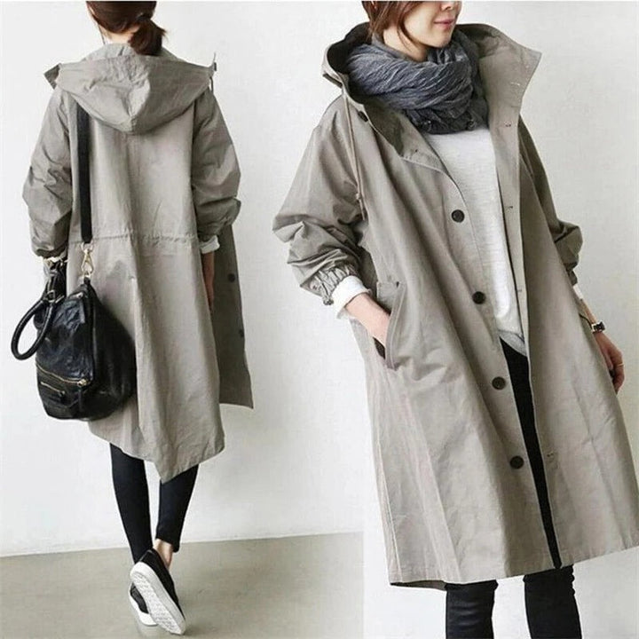 Women's hooded waterproof trench coat, front view. Adjustable hood, belted waist, available in various colors.