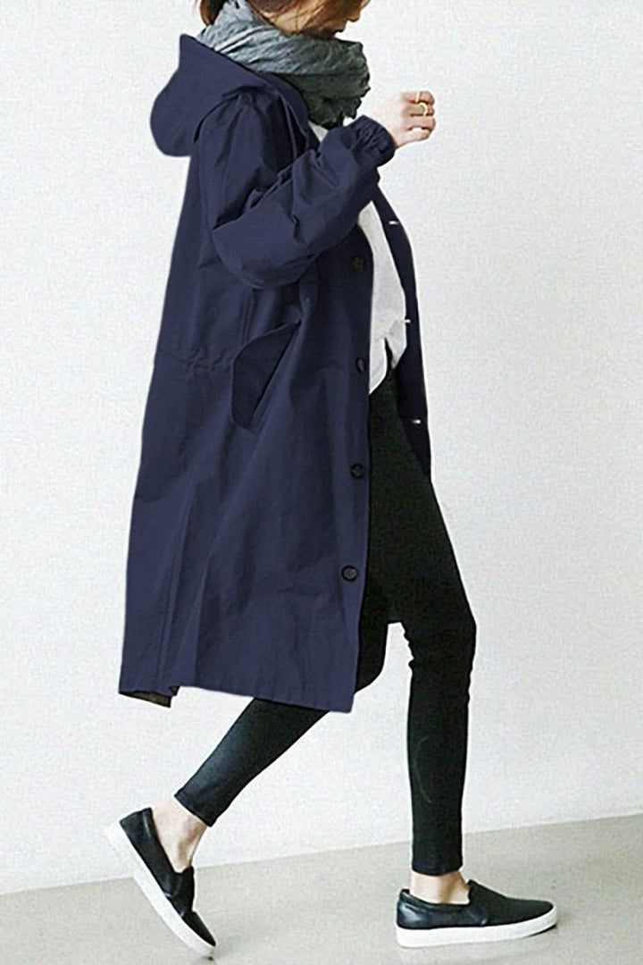 Women's hooded waterproof trench coat, front view. Adjustable hood, belted waist, available in various colors.