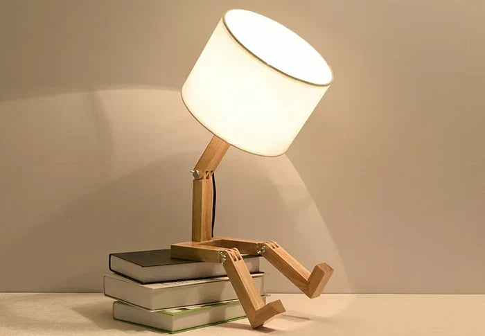 Unique wooden robot lamp with adjustable body, ideal as a reading or table lamp.