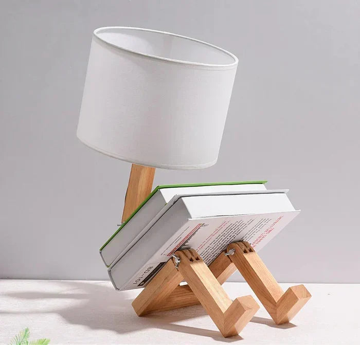 Adjustable wooden robot desk lamp. Playful design, functional lighting for reading or work.