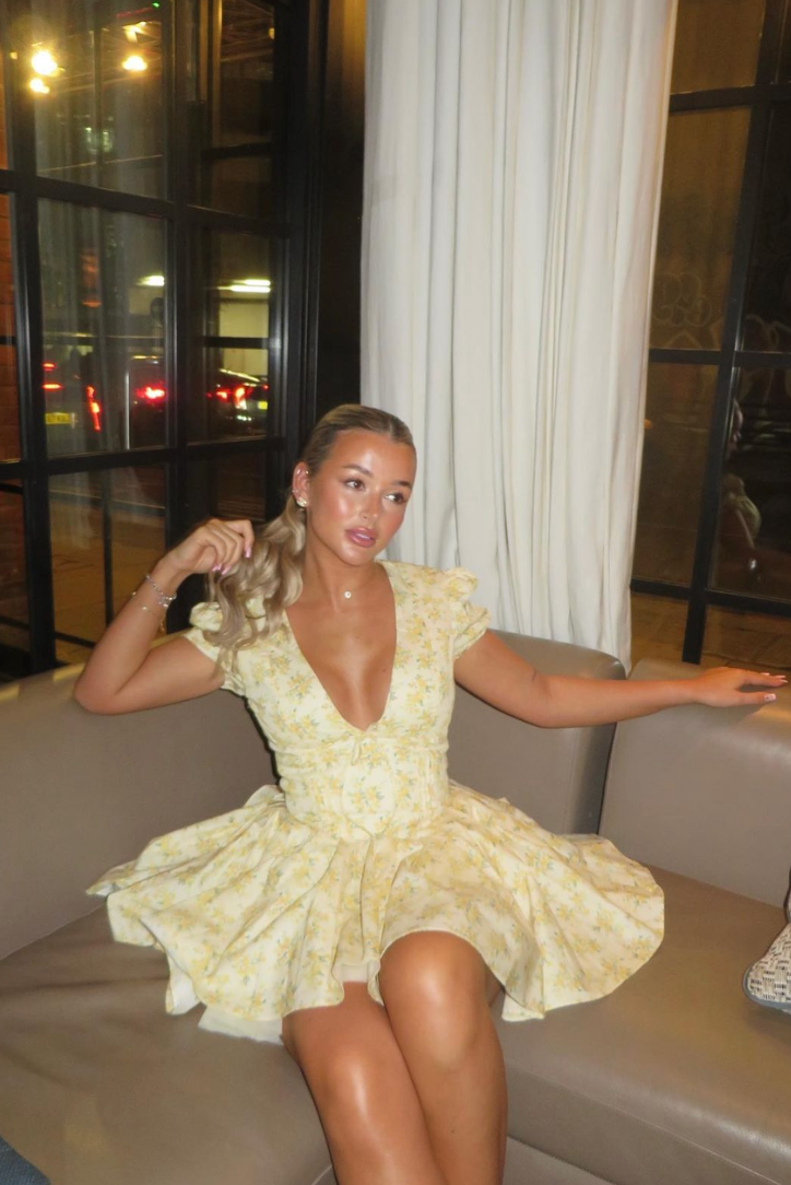 Casual women's floral A-line mini dress in yellow, featuring puff sleeves & an open back. Comfortable summer wear.